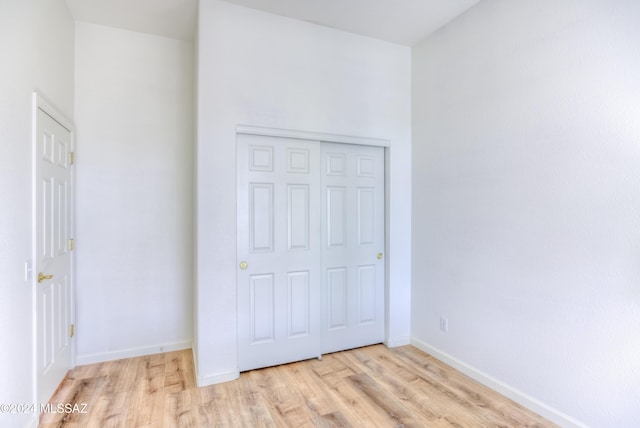 unfurnished bedroom with light hardwood / wood-style floors and a closet