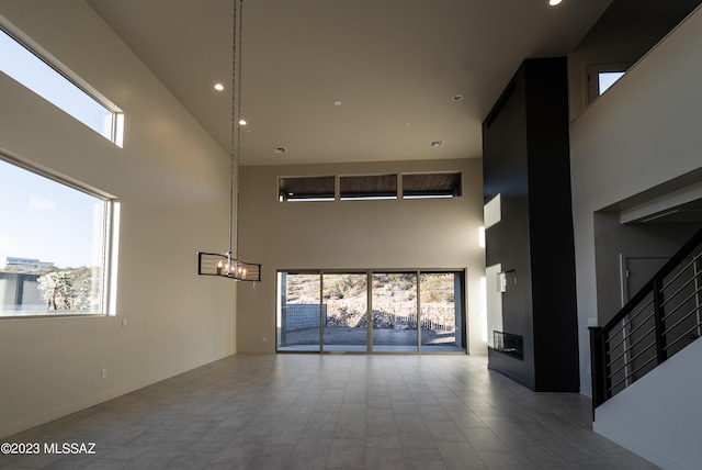 unfurnished living room featuring a towering ceiling