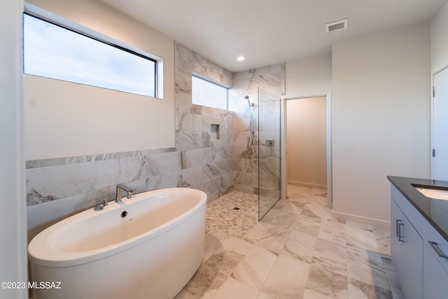 bathroom with vanity, separate shower and tub, and tile walls