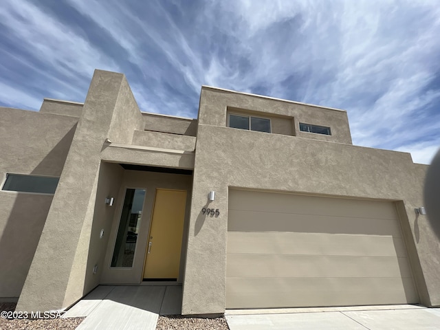 pueblo revival-style home featuring a garage