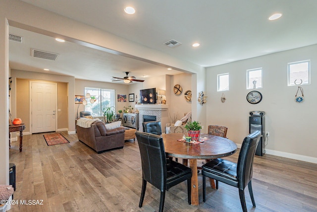 dining space with ceiling fan and light wood-type flooring