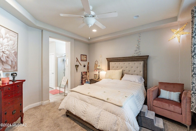 carpeted bedroom with a tray ceiling and ceiling fan