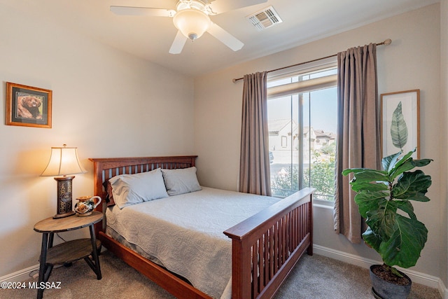 carpeted bedroom featuring multiple windows and ceiling fan