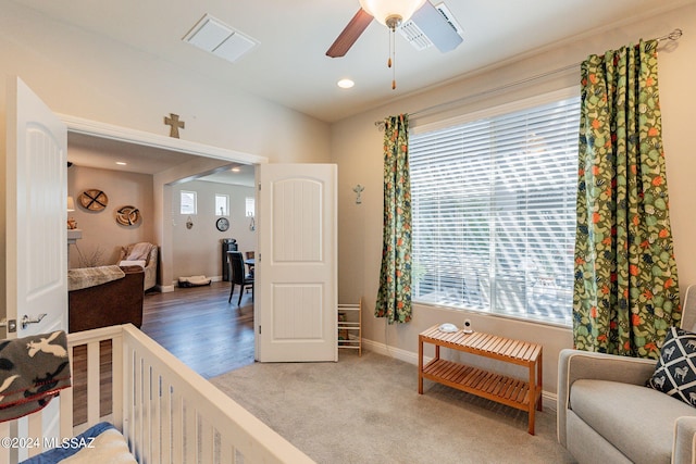 bedroom featuring ceiling fan, carpet floors, and a nursery area