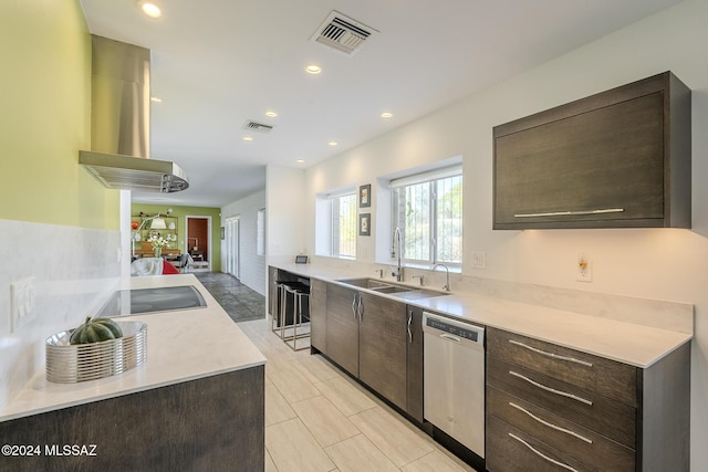 kitchen with dark brown cabinetry, range hood, stainless steel dishwasher, and sink