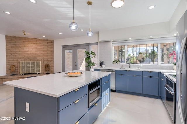 kitchen featuring sink, stainless steel appliances, a center island, decorative backsplash, and blue cabinetry