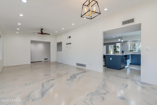 empty room featuring ceiling fan with notable chandelier