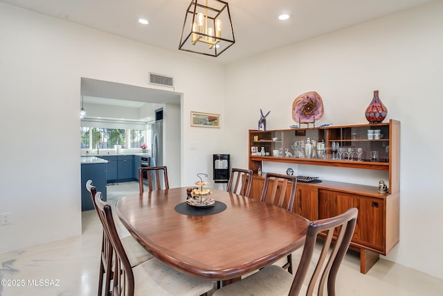 dining space featuring sink and an inviting chandelier