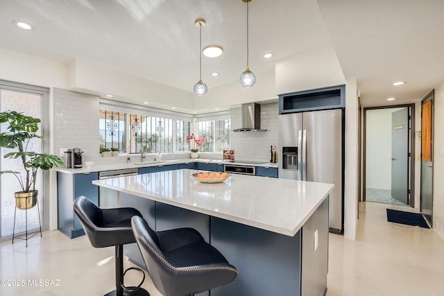 kitchen with a kitchen island, wall chimney exhaust hood, stainless steel refrigerator with ice dispenser, and decorative light fixtures