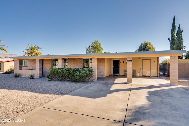 ranch-style home featuring a carport and central air condition unit