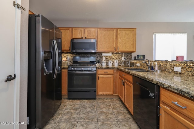 kitchen featuring sink, tasteful backsplash, dark stone countertops, and black appliances