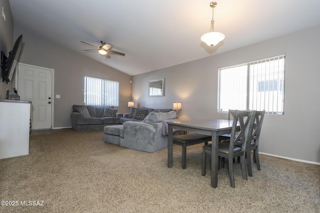 carpeted dining area with ceiling fan and lofted ceiling