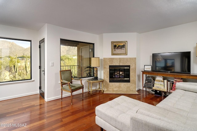 living room with hardwood / wood-style floors and a tiled fireplace