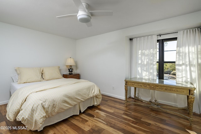 bedroom with dark hardwood / wood-style flooring and ceiling fan