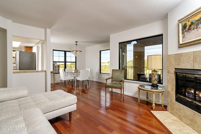 living room featuring a tiled fireplace and hardwood / wood-style flooring