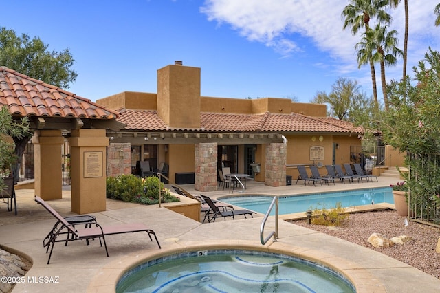 view of swimming pool with a hot tub and a patio area