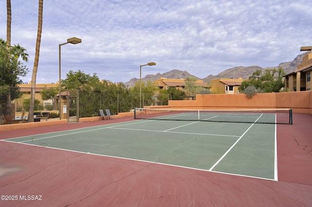 view of sport court featuring a mountain view and basketball hoop