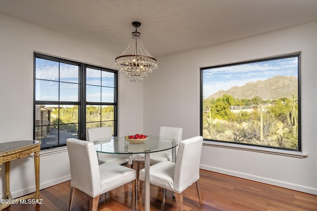 dining room featuring a chandelier, a mountain view, hardwood / wood-style flooring, and a wealth of natural light