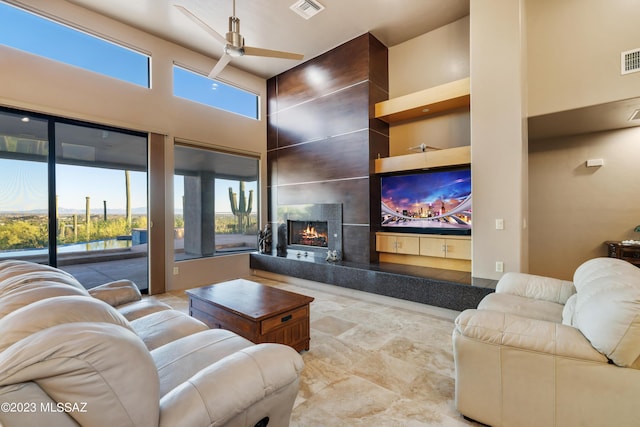 living room featuring a high ceiling, plenty of natural light, and ceiling fan