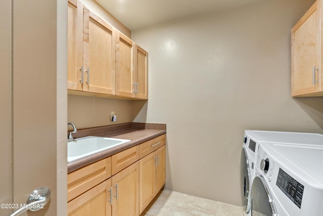 laundry area featuring cabinets, independent washer and dryer, and sink