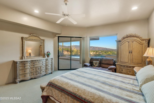 bedroom featuring access to exterior, a mountain view, light carpet, and ceiling fan