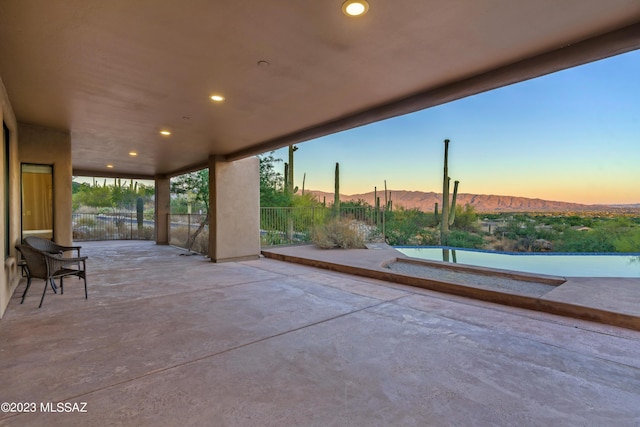 patio terrace at dusk with a water and mountain view