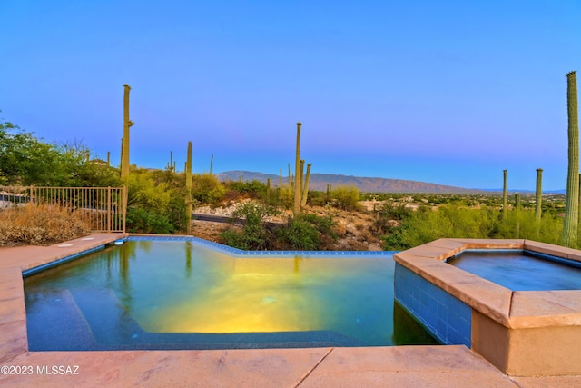 view of swimming pool featuring a mountain view and an in ground hot tub