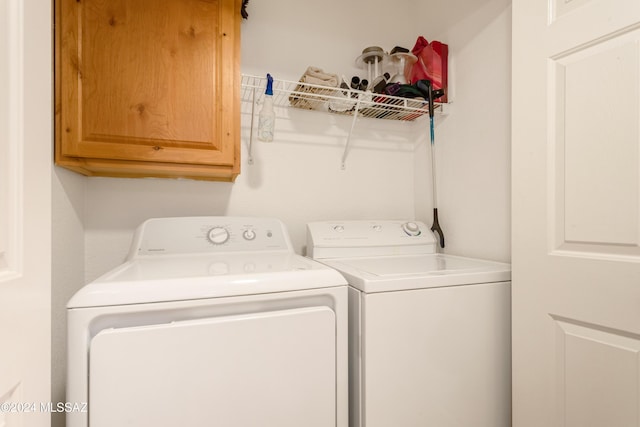 laundry room with washer and dryer and cabinets