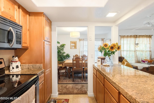 kitchen with light tile patterned floors, black range with electric cooktop, and ceiling fan