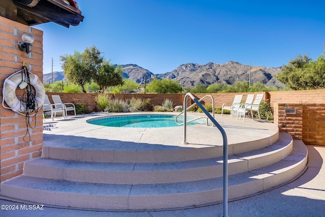 view of pool with a mountain view and a patio area