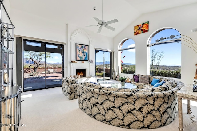 carpeted living room featuring ceiling fan, a mountain view, and lofted ceiling