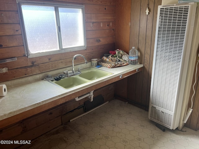 kitchen featuring wood walls and sink