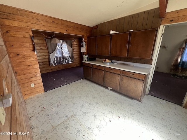 kitchen with wooden walls and dark brown cabinets