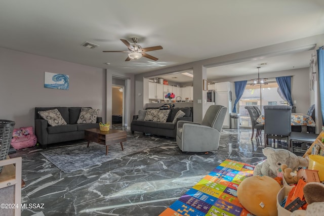 living room with ceiling fan with notable chandelier