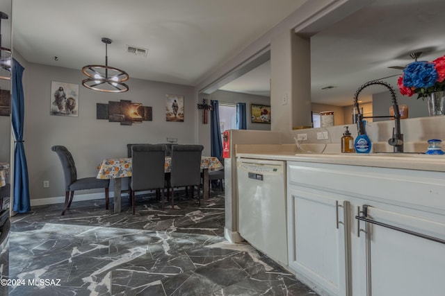 kitchen featuring white dishwasher, sink, decorative light fixtures, white cabinets, and a chandelier