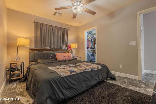 bedroom featuring a walk in closet, a closet, and ceiling fan