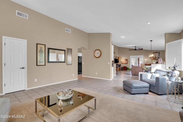 living room featuring ceiling fan with notable chandelier and light tile patterned floors