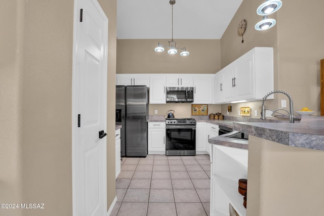 kitchen featuring white cabinets, pendant lighting, light tile patterned floors, and appliances with stainless steel finishes