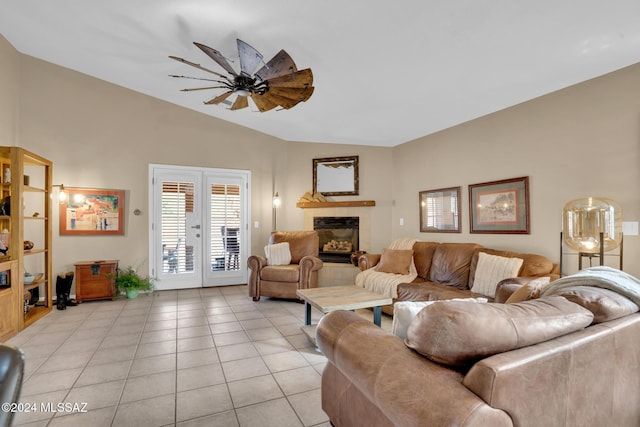 tiled living room featuring a tile fireplace, ceiling fan, and lofted ceiling