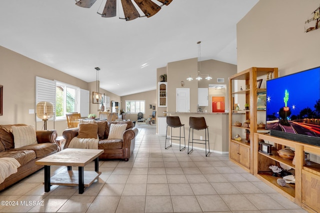 living room featuring light tile patterned floors, ceiling fan with notable chandelier, and lofted ceiling