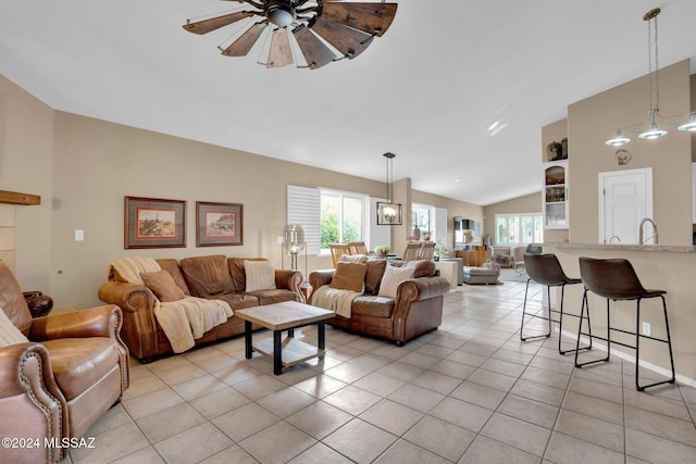 tiled living room featuring ceiling fan, sink, and vaulted ceiling