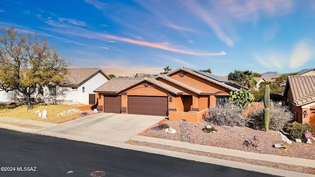 view of front of home featuring solar panels and a garage