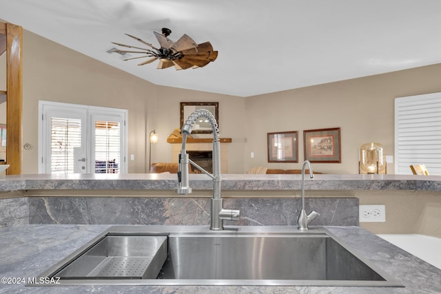 kitchen with ceiling fan, lofted ceiling, and sink