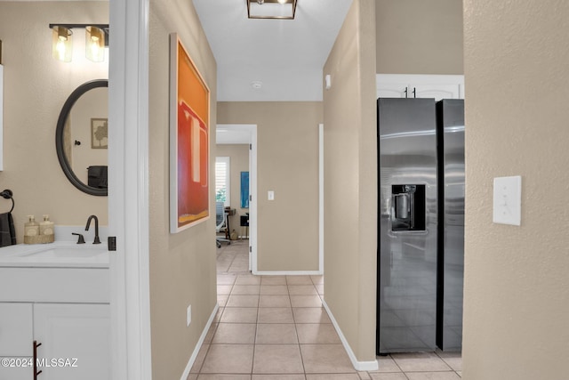 hall with sink and light tile patterned flooring