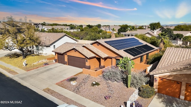 view of front of house with a garage and solar panels