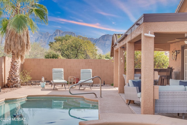 view of swimming pool with a mountain view, a patio, and an outdoor hangout area