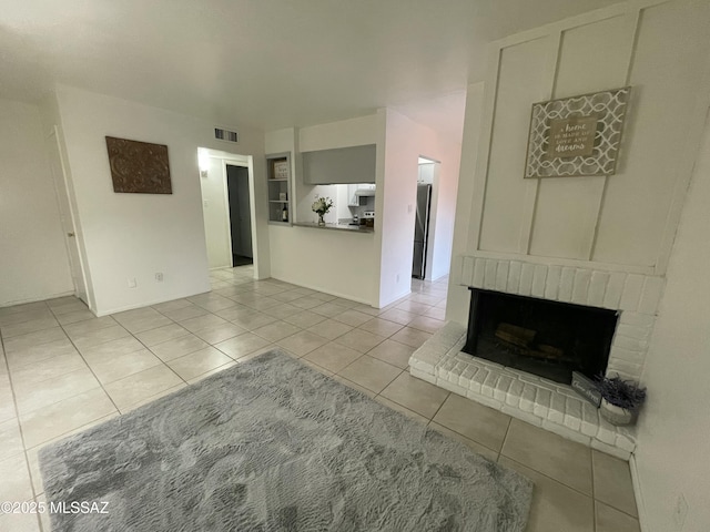 unfurnished living room featuring light tile patterned floors, a fireplace, and visible vents