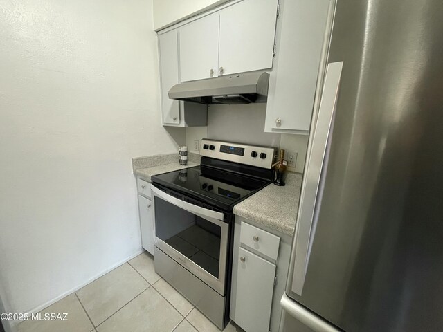 kitchen featuring white cabinetry, appliances with stainless steel finishes, wall chimney exhaust hood, and light tile patterned floors