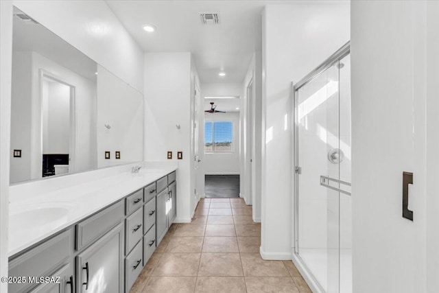 bathroom with tile patterned flooring, vanity, and a shower with door