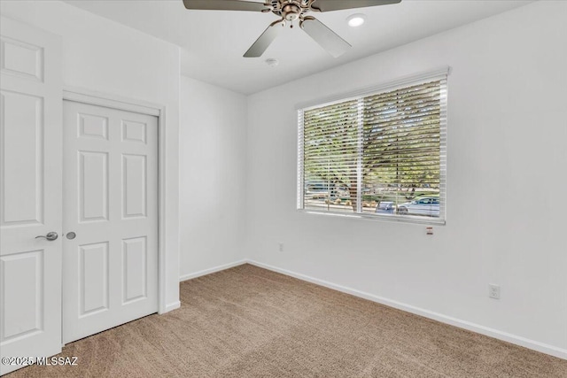 unfurnished bedroom with ceiling fan, light carpet, and a closet